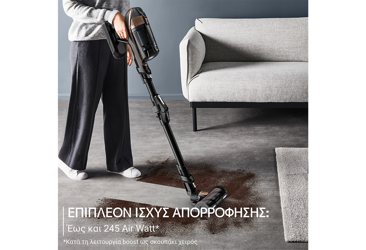 Απεικονίζεται γυναίκα να σκουπίζει χώμα σε σαλόνι.